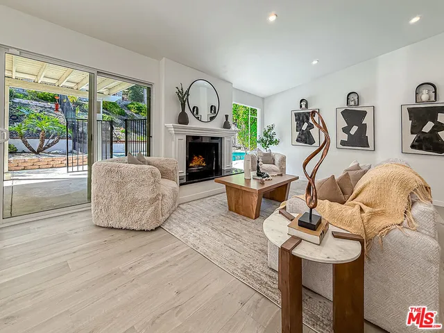 a living room with furniture a fireplace and a floor to ceiling window