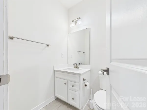 a bathroom with a bathtub shower sink vanity mirror and toilet