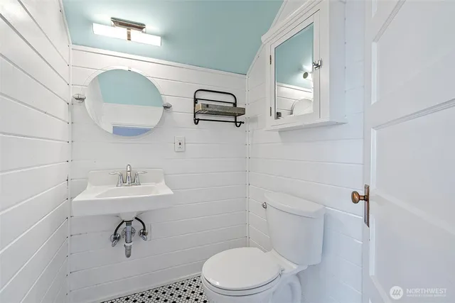 a bathroom with a toilet sink and mirror