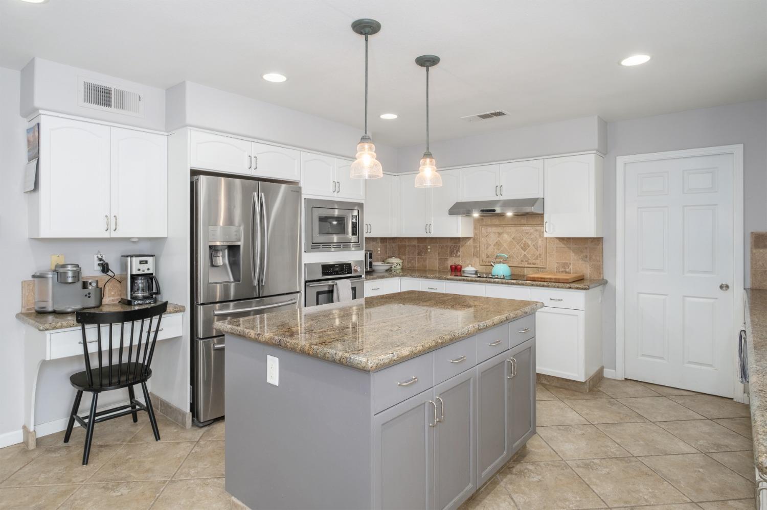 452 Omaha Avenue Clovis, CA 93619 - Photo 12 of 33 a kitchen with stainless steel appliances granite countertop a sink a counter and chairs