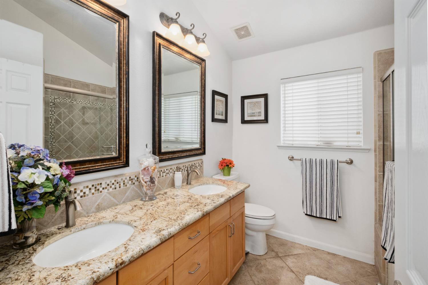 452 Omaha Avenue Clovis, CA 93619 - Photo 16 of 33 a bathroom with a granite countertop sink and a mirror