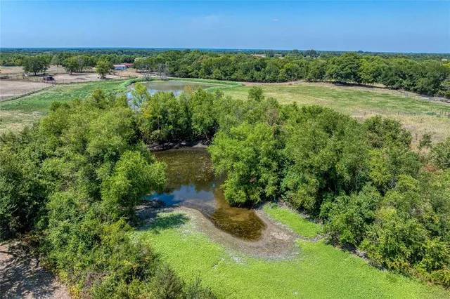 an aerial view of residential houses with outdoor space and trees