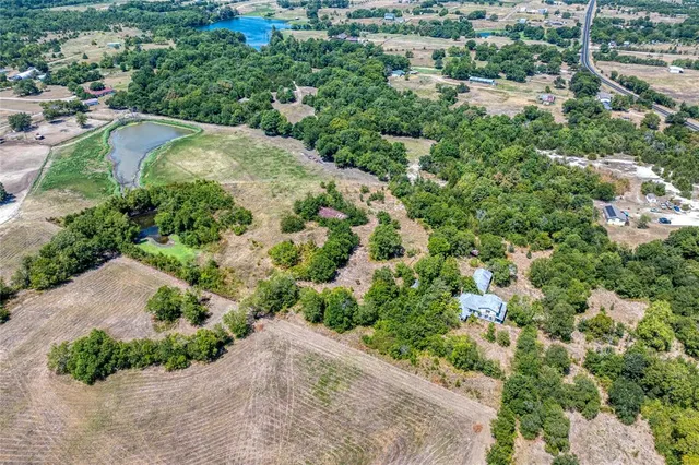 an aerial view of a house with a yard and greenery