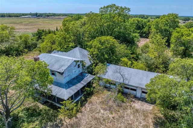 an aerial view of a house with garden space and a bench