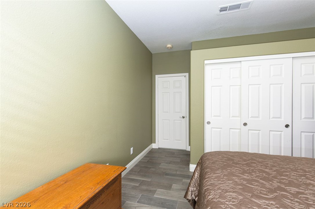 4670 Los Rancheros Avenue Las Vegas, NV 89129 - Photo 35 of 57 A spacious bedroom features neutral toned walls, clean lines, and durable tile flooring.