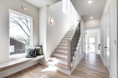 a view of a hallway with wooden floor and entryway