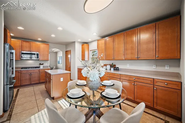 a large kitchen with stainless steel appliances kitchen island granite countertop a sink and cabinets