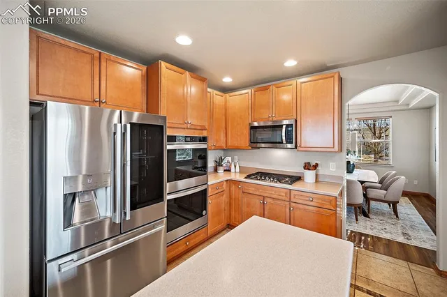 a kitchen with stainless steel appliances granite countertop a refrigerator a stove microwave and sink