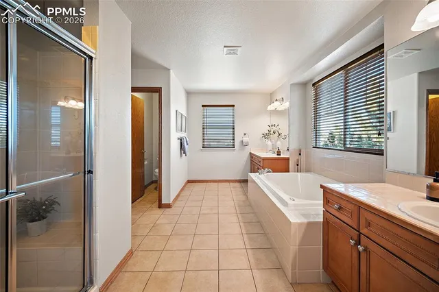 a large bathroom with a large mirror vanity and bathtub
