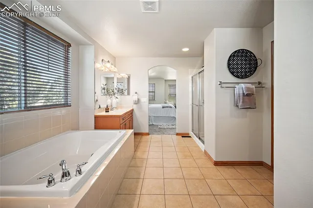 a large bathroom with a tub a mirror and a shower