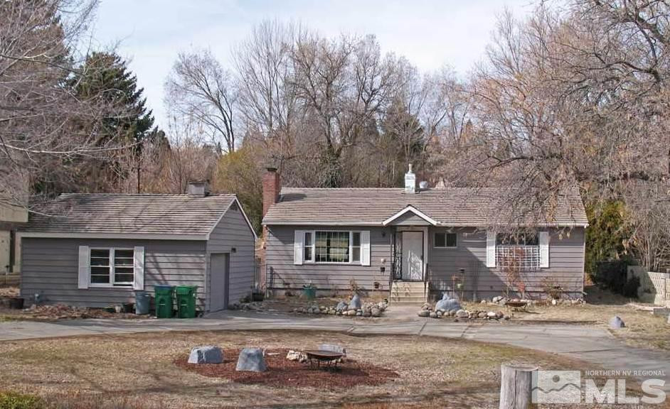 a front view of a house with yard and trees