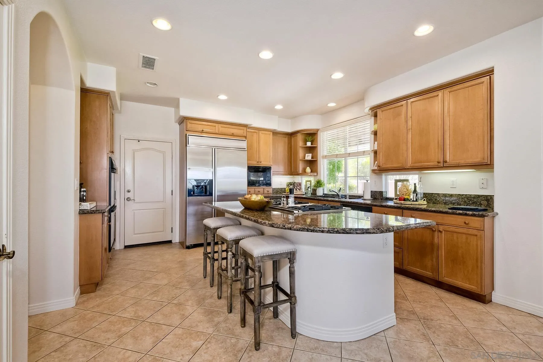 13660 Overland Pass Road Poway, CA 92064 - Photo 16 of 61 a kitchen with stainless steel appliances granite countertop table chairs sink refrigerator and cabinets