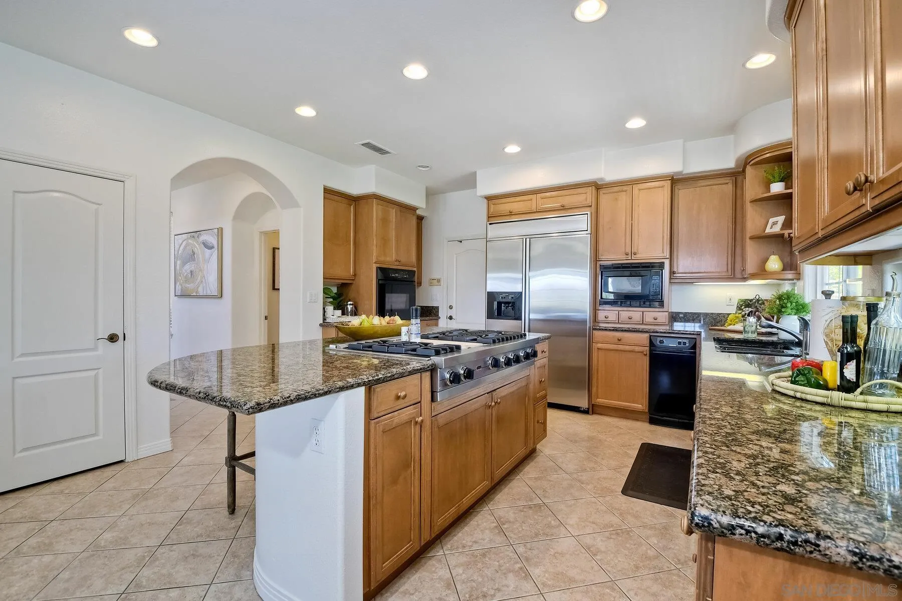 13660 Overland Pass Road Poway, CA 92064 - Photo 17 of 61 a kitchen with stainless steel appliances granite countertop a stove top oven a sink dishwasher and cabinets with wooden floor