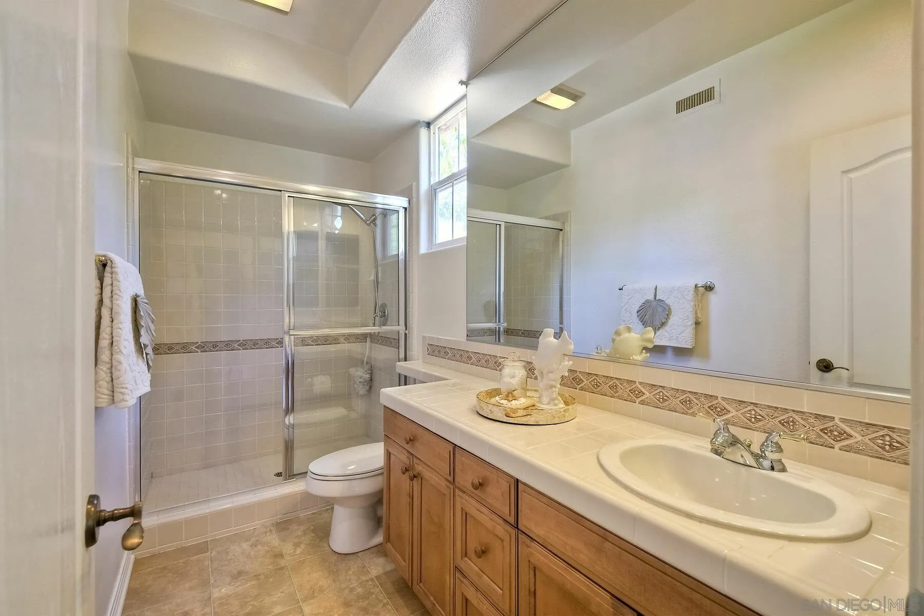 13660 Overland Pass Road Poway, CA 92064 - Photo 28 of 61 a bathroom with a granite countertop sink toilet and shower