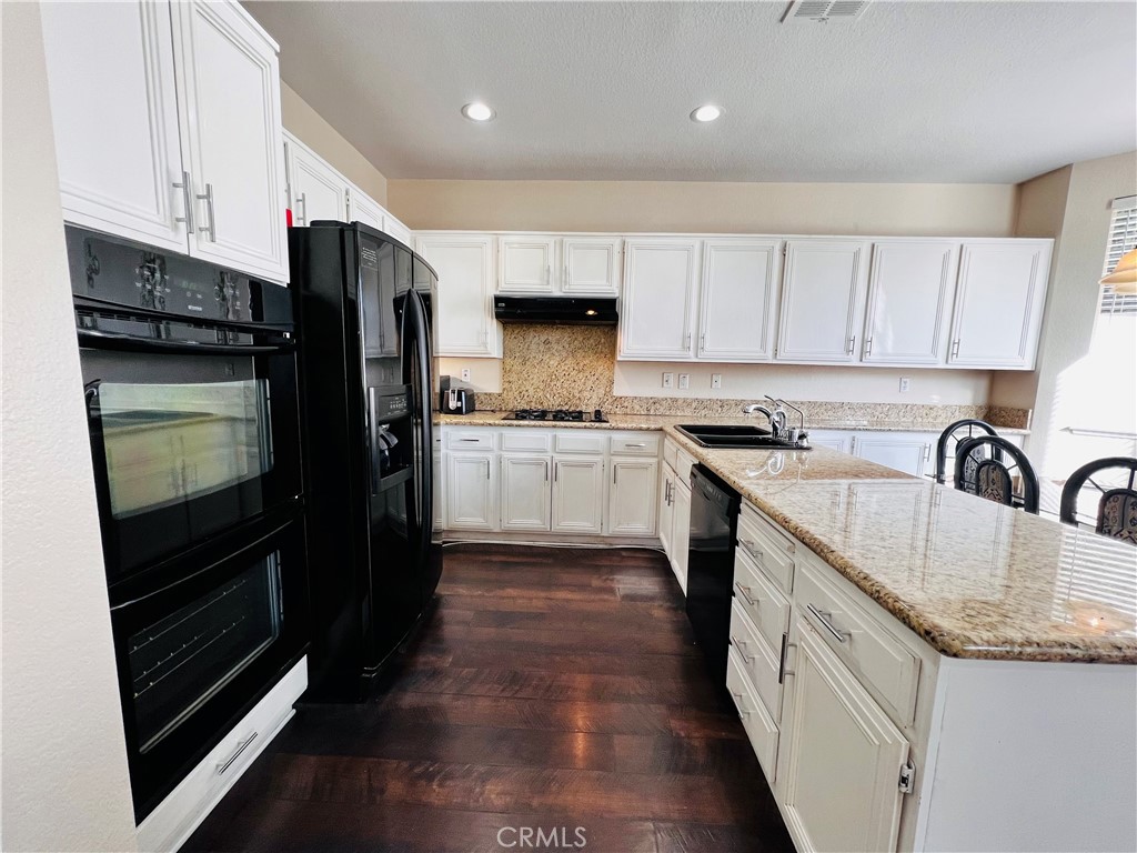 743 Orchard Loop Azusa, CA 91702 - Photo 11 of 38 a kitchen with granite countertop a refrigerator stove top oven and sink