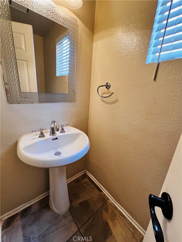 743 Orchard Loop Azusa, CA 91702 - Photo 20 of 38 a bathroom with a sink a mirror and shower
