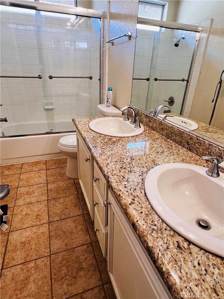743 Orchard Loop Azusa, CA 91702 - Photo 21 of 38 a bathroom with a granite countertop sink a mirror and shower