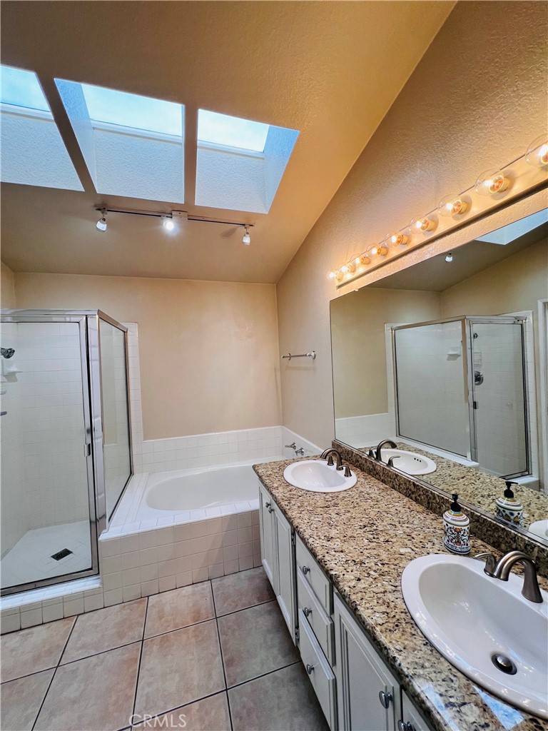 743 Orchard Loop Azusa, CA 91702 - Photo 28 of 38 a bathroom with a granite countertop bathtub sink vanity and mirror
