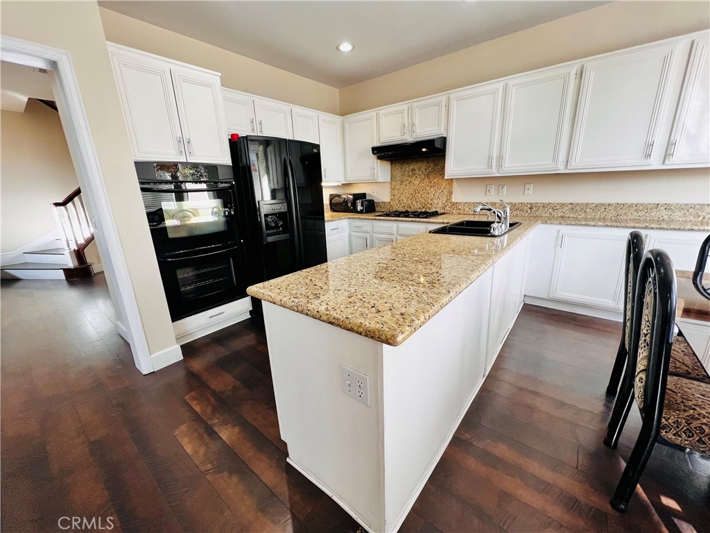 743 Orchard Loop Azusa, CA 91702 - Photo 10 of 38 a kitchen with a refrigerator a stove top oven a sink and dishwasher