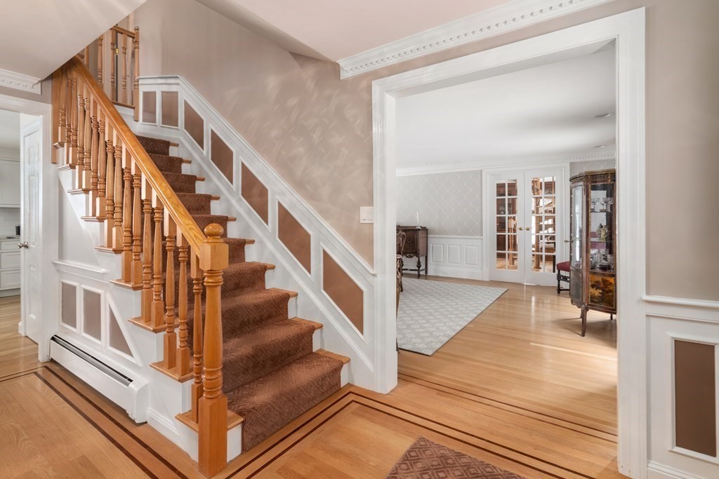 22 Hillcrest Road Weston, MA 02493 - Photo 18 of 31 a view of staircase with lots of frames on wall and a dining table
