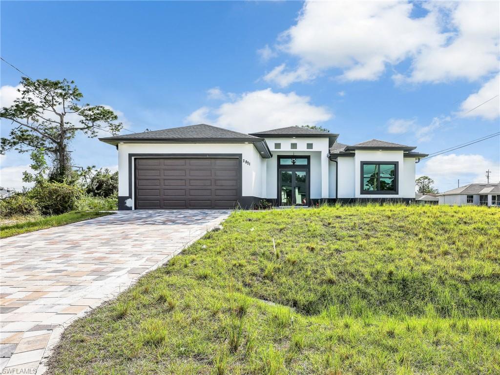 350 Delaware Road Lehigh Acres, FL 33936 - Photo 1 of 30 a front view of a house with garden