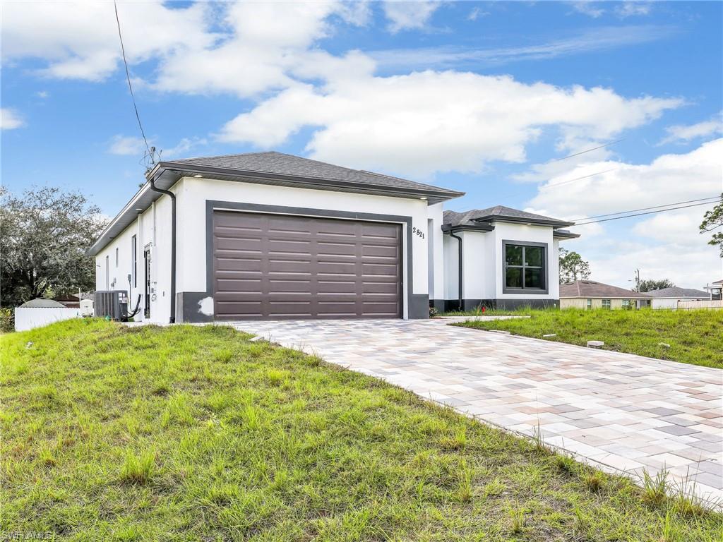 350 Delaware Road Lehigh Acres, FL 33936 - Photo 3 of 30 a front view of a house with a yard and garage