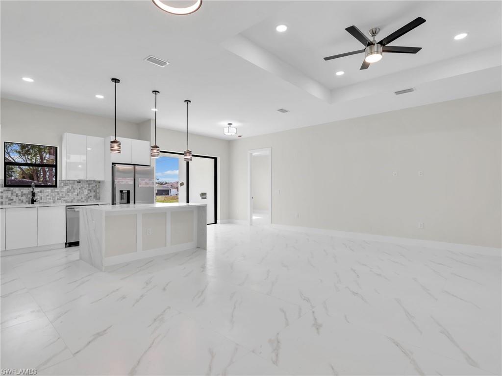 350 Delaware Road Lehigh Acres, FL 33936 - Photo 8 of 30 a large kitchen with stainless steel appliances kitchen island a white counter space cabinets and a sink