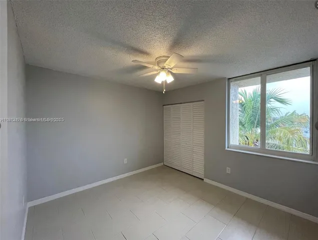 an empty room with a window and a fan