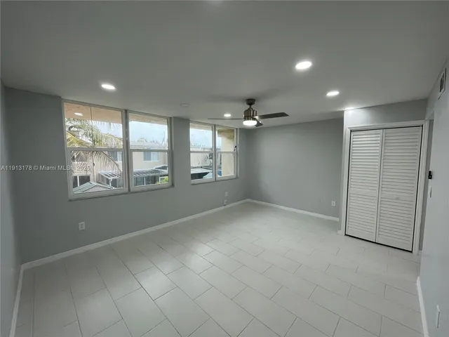 an empty room with windows and closet