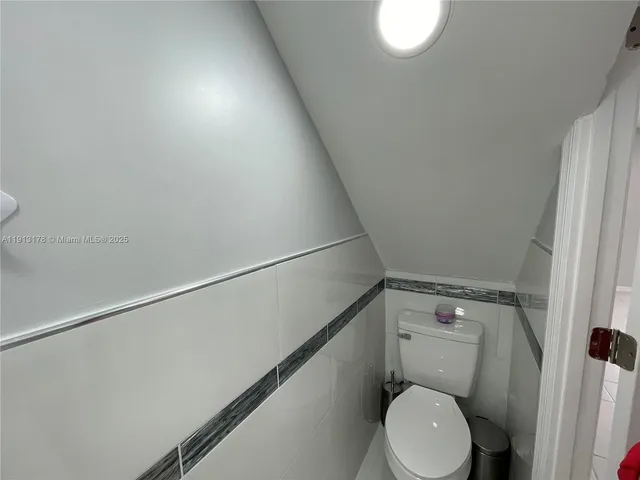 a white toilet sitting next to a shower