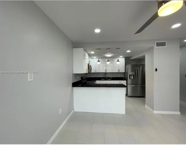 a kitchen with a refrigerator and a sink