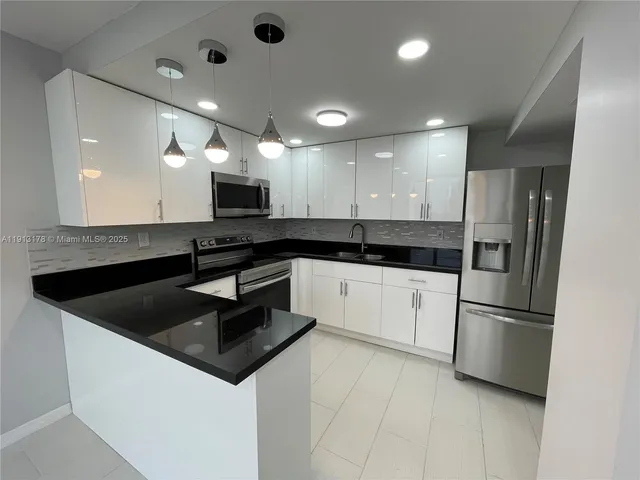 a kitchen with granite countertop a refrigerator and a sink