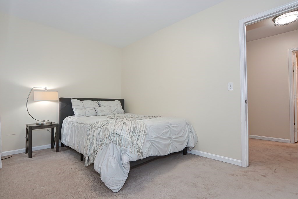 7 Proctor Road Pepperell, MA 01463 - Photo 19 of 40 a spacious bedroom with a bed and a lamp