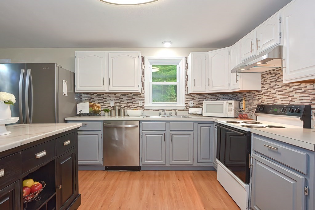 7 Proctor Road Pepperell, MA 01463 - Photo 3 of 40 a kitchen with a sink stove and cabinets