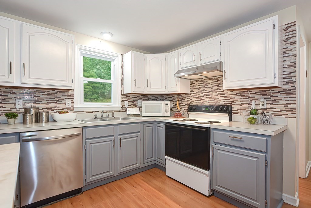 7 Proctor Road Pepperell, MA 01463 - Photo 4 of 40 a kitchen with a sink stove and cabinets