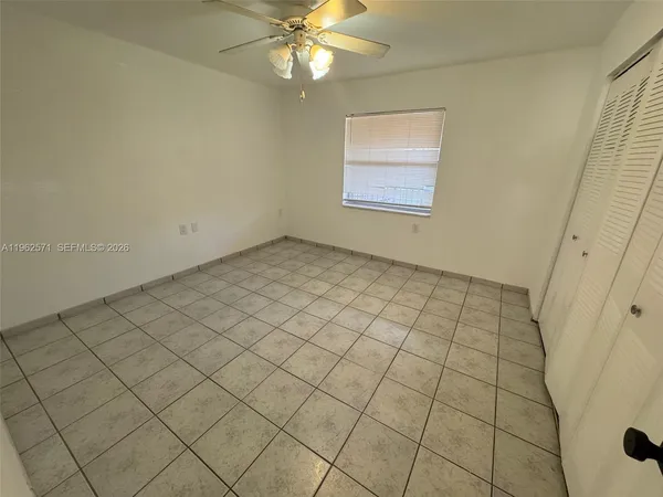 a view of an empty room and chandelier fan