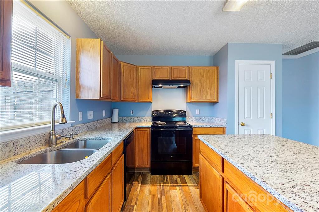 4262 Barley Street Southwest Concord, NC 28027 - Photo 1 of 27 a kitchen with granite countertop a sink a counter top space and cabinets