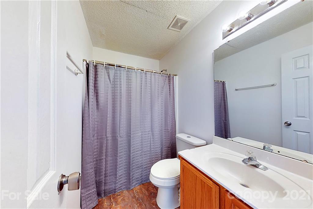 4262 Barley Street Southwest Concord, NC 28027 - Photo 16 of 27 a bathroom with a sink a toilet and shower curtain