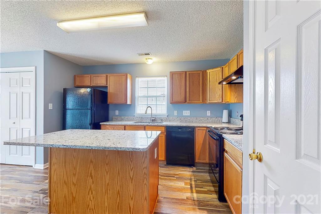 4262 Barley Street Southwest Concord, NC 28027 - Photo 4 of 27 a kitchen with stainless steel appliances granite countertop wooden cabinets a sink and a stove