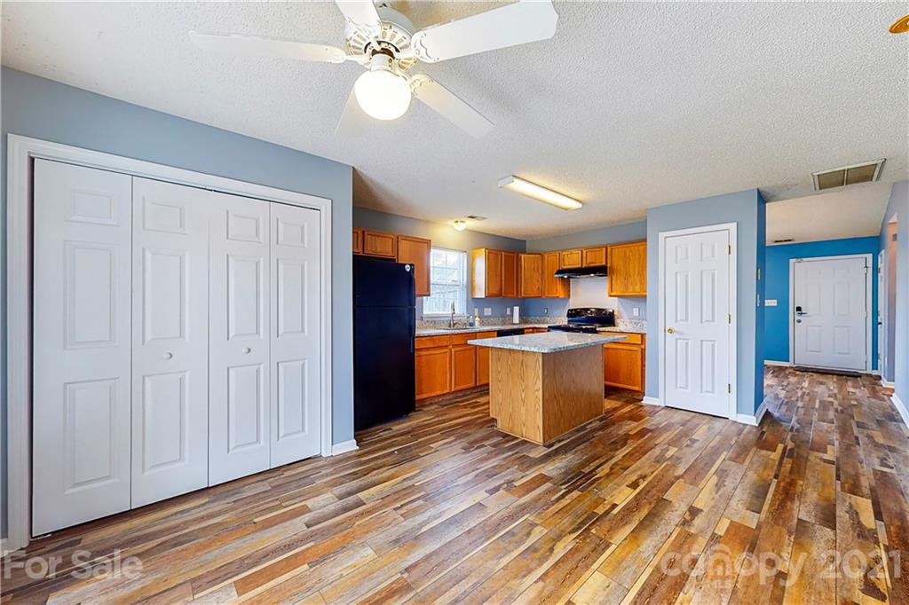 4262 Barley Street Southwest Concord, NC 28027 - Photo 5 of 27 a view of a kitchen with kitchen island wooden floors appliances and cabinets