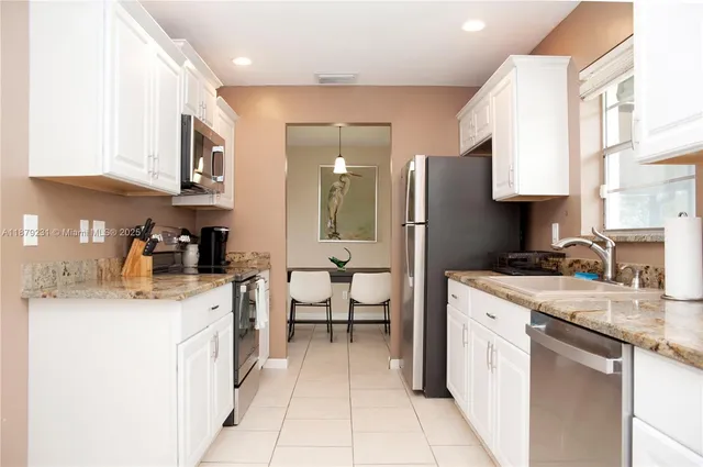 a kitchen that has a lot of white cabinets
