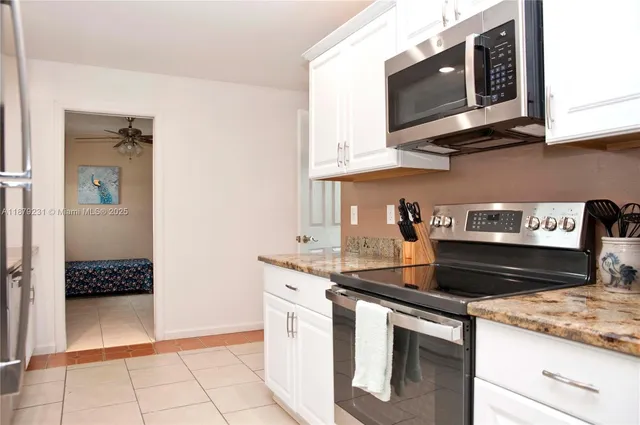 a kitchen with stainless steel appliances granite countertop a sink stove and microwave