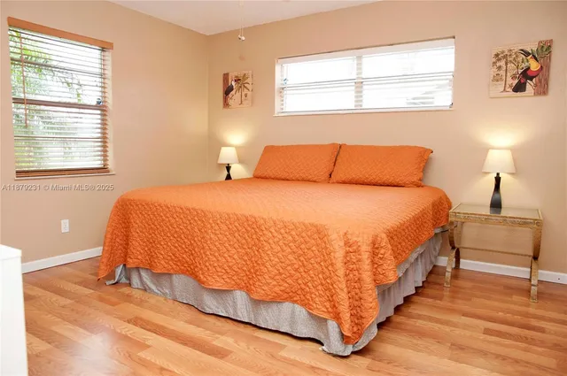 a large bed sitting in a bedroom next to a window