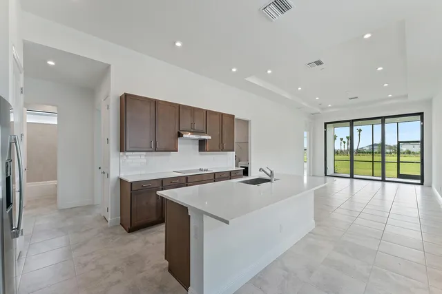 a kitchen with kitchen island sink refrigerator and stove