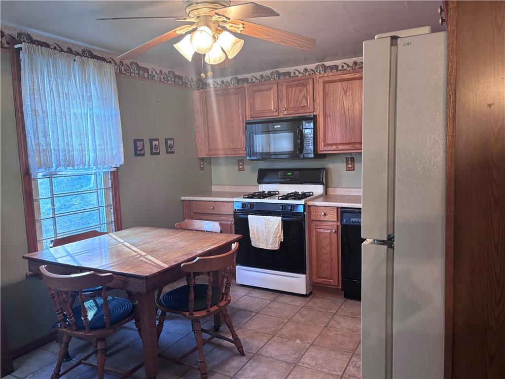 1776 Main Street Allenport, PA 15412 - Photo 3 of 16 a kitchen with stainless steel appliances a table chairs and a refrigerator