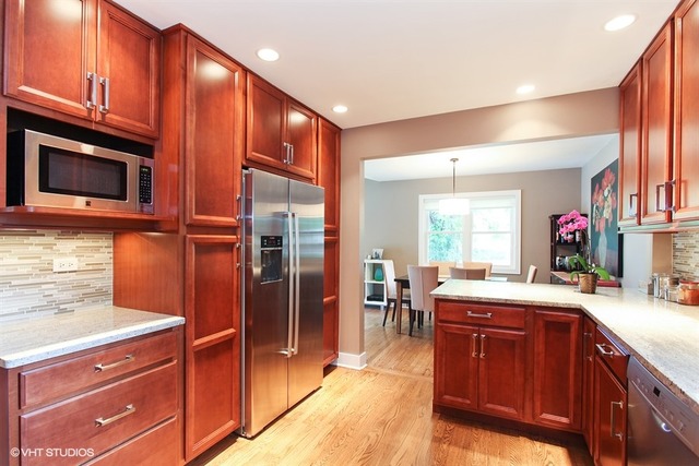 1230 Kenton Road Deerfield, IL 60015 - Photo 8 of 22 a kitchen with granite countertop stainless steel appliances and wooden cabinets