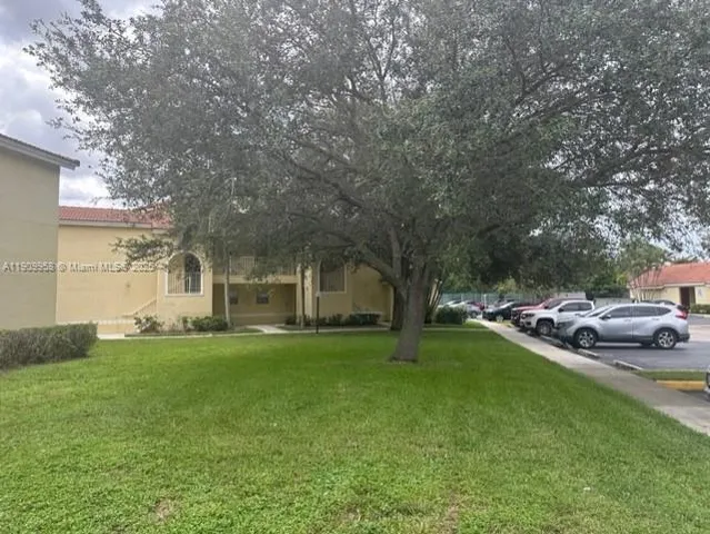 a front view of a house with a garden and trees
