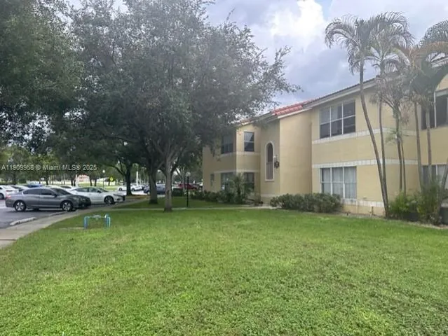 a view of a house with a yard and sitting area