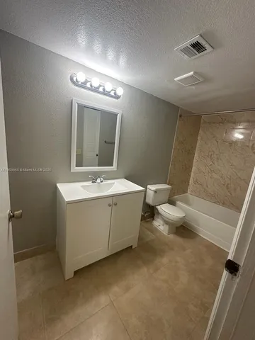 a bathroom with a double vanity sink mirror and toilet