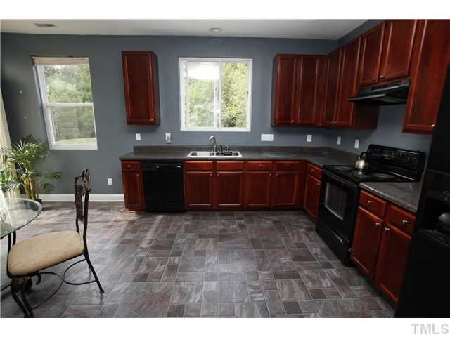 2605 Quarry Ridge Lane Raleigh, NC 27610 - Photo 4 of 8 a kitchen with granite countertop a stove a sink a window and dining table